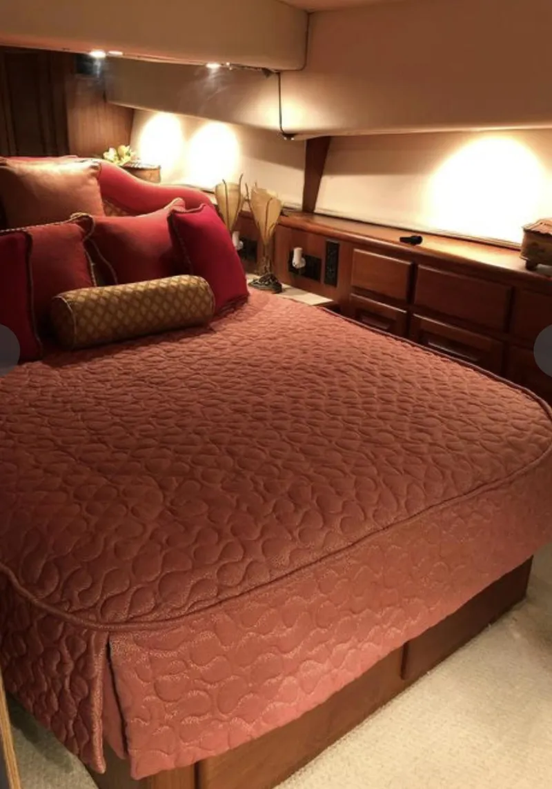 Slide: The Image of Luxurious bedroom interior of a 1995 Viking 58 Convertible yacht with elegant bedding. - 6