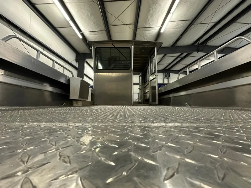 Slide: The Image of 2024 Bayview Boats 26 Landing Craft in a warehouse, showcasing diamond plate flooring. - 11