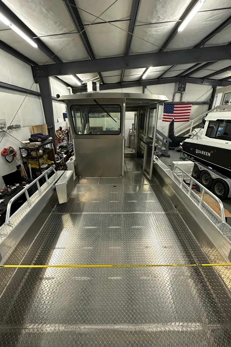 Slide: The Image of 2024 Bayview Boats 26 Landing Craft in a warehouse, showcasing its spacious deck. - 21