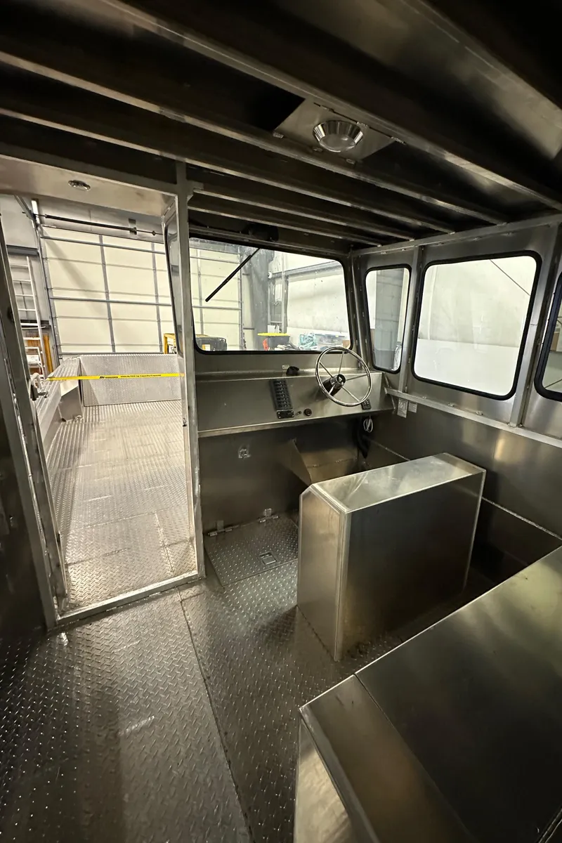 Slide: The Image of 2024 Bayview Boats 26 Landing Craft interior with steering console and metal flooring. - 23