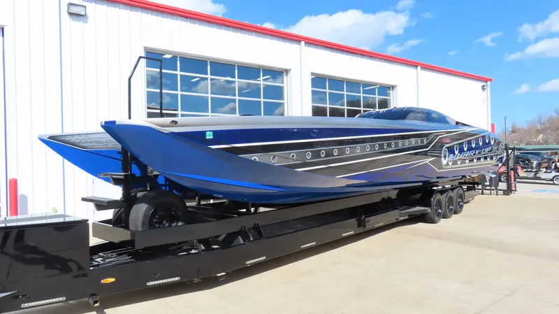 Slide: The Image of 2020 Outerlimits 46SC powerboat on a trailer outside a building. - 2