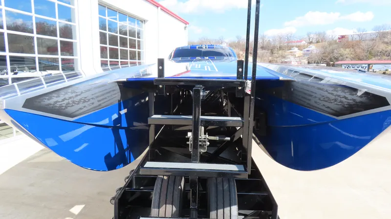 Slide: The Image of 2020 Outerlimits 46SC powerboat on trailer, blue hull, parked outdoors. - 3