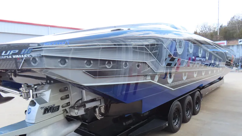 Slide: The Image of 2020 Outerlimits 46SC powerboat on a trailer, showcasing sleek design and vibrant blue graphics. - 5