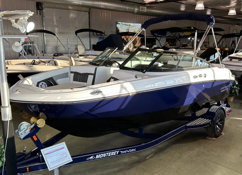 Slide: The Image of 2024 Monterey M205 Family Bowrider boat displayed indoors on a trailer. - 1
