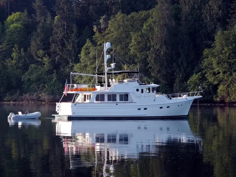 Slide: The Image of Selene 54 Classic Explorer yacht on calm water, surrounded by lush forest, 2026 model. - 22