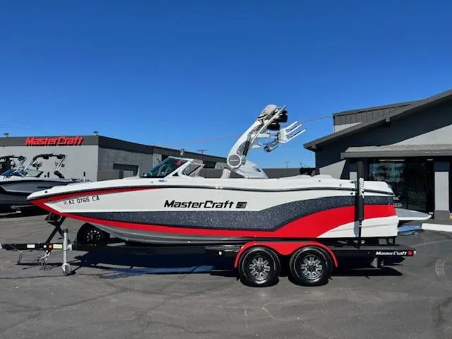 Slide: The Image of 2018 MasterCraft XT22 boat on a trailer outside a dealership. - 1