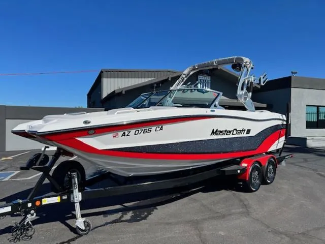 Slide: The Image of 2018 MasterCraft XT22 boat on trailer in parking lot. - 2