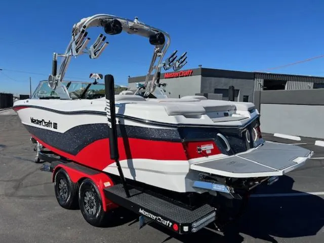 Slide: The Image of 2018 MasterCraft XT22 boat with red, white, and black design on a trailer. - 8
