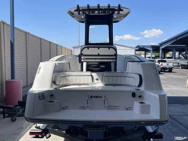 Slide: The Image of 2024 Yamaha Boats 255 FSH Sport H, rear view, parked outdoors. - 2