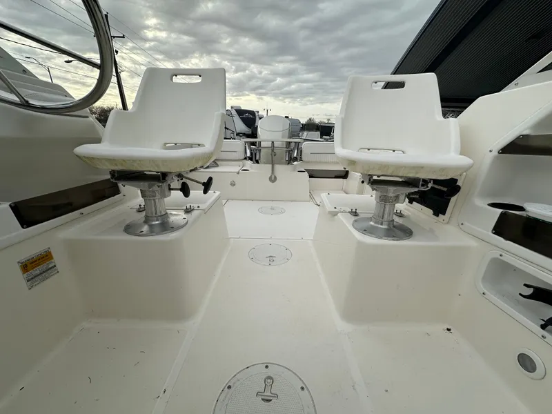 Slide: The Image of 1998 Boston Whaler 23 Conquest boat interior with two white captain chairs. - 15