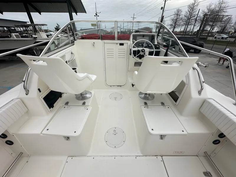 Slide: The Image of 1998 Boston Whaler 23 Conquest boat cockpit with dual white seats and steering console. - 9