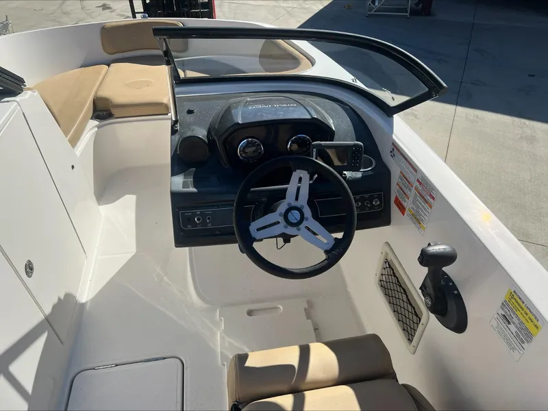 Slide: The Image of 2021 Bayliner VR6 boat cockpit with steering wheel and seating. - 9