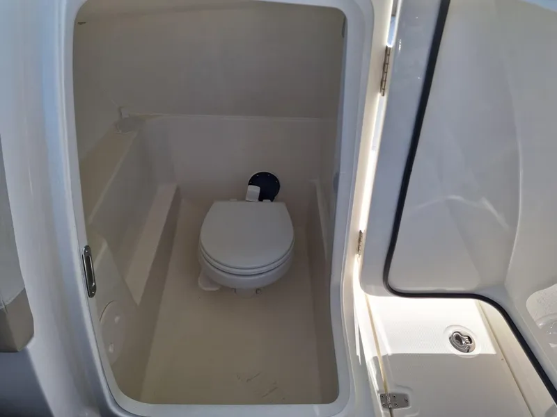 Slide: The Image of 2022 Boston Whaler 240 Vantage boat interior with compact marine toilet. - 8