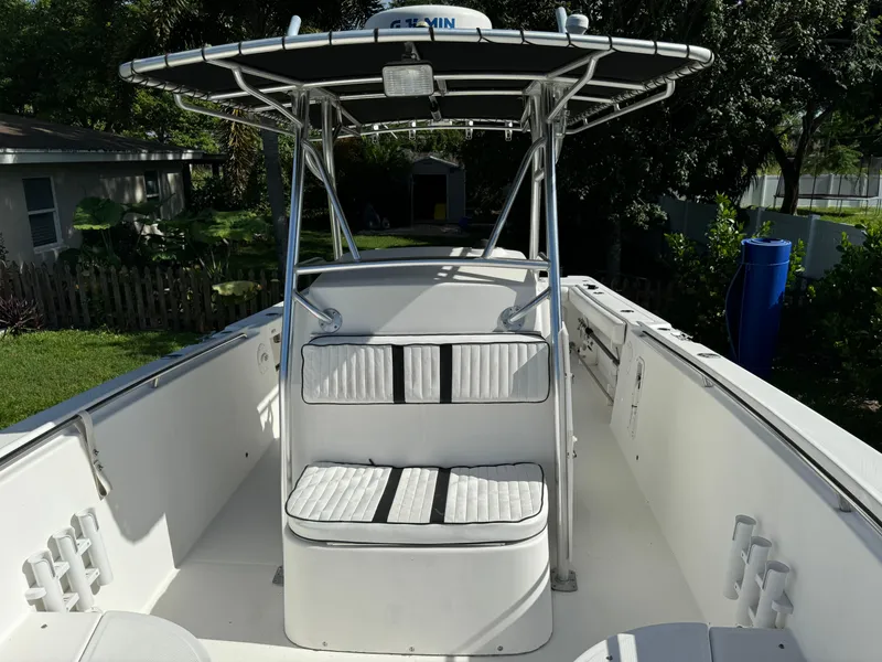 Slide: The Image of 2002 Edgewater 260 Center Console boat with seating and T-top in a residential yard. - 10