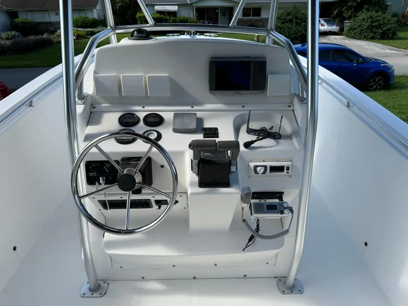 Slide: The Image of Edgewater 260 Center Console 2002 boat dashboard with steering wheel and navigation equipment. - 13