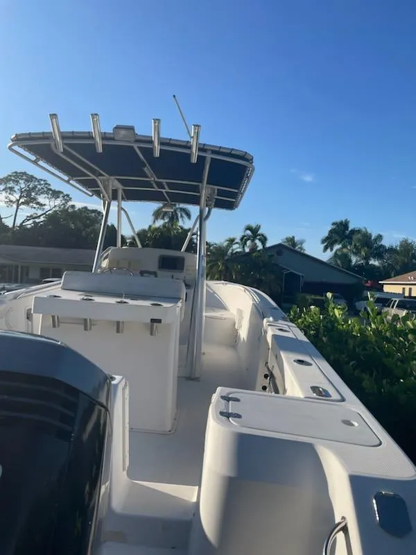 Slide: The Image of 2002 Edgewater 260 Center Console boat with T-top in a residential area. - 22