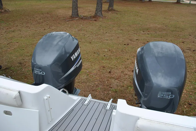 Slide: The Image of Twin Yamaha 250 outboard motors on a 2001 ProKat 2800KAT boat, parked on grass. - 16
