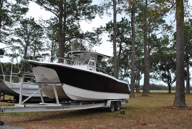 Slide: The Image of 2001 ProKat 2800KAT boat on trailer in wooded area. - 26