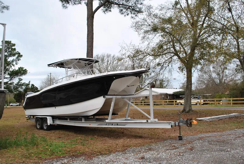 Slide: The Image of 2001 ProKat 2800KAT boat on trailer, parked outdoors among trees. - 27