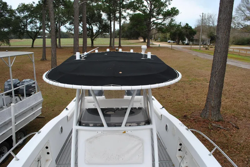 Slide: The Image of 2001 ProKat 2800KAT boat with black canopy, parked outdoors near trees. - 6