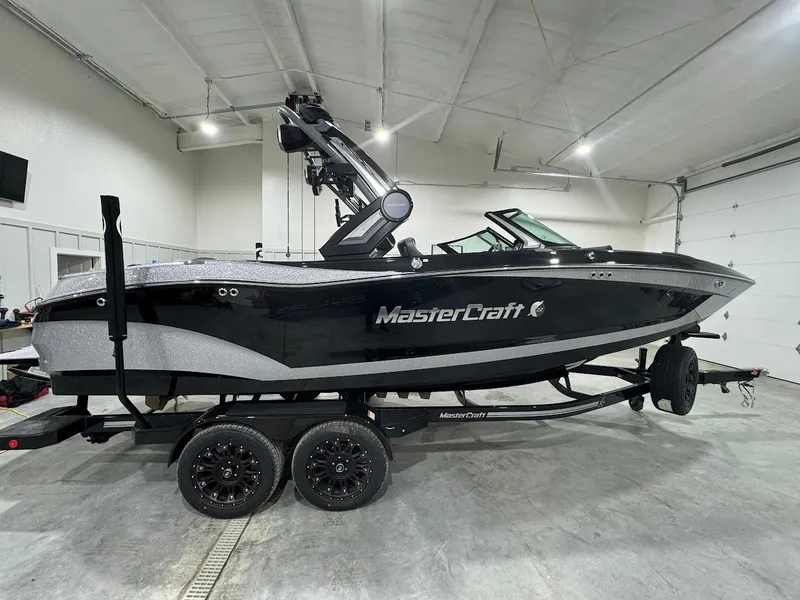 Slide: The Image of 2024 MasterCraft X22 boat in a garage, black and silver exterior. - 10