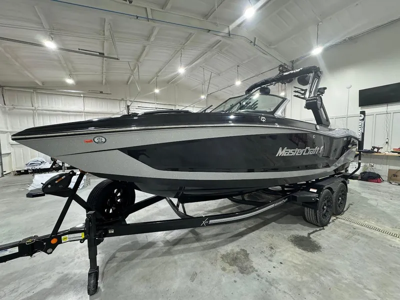 Slide: The Image of 2024 MasterCraft X22 boat in a showroom on a trailer. - 13