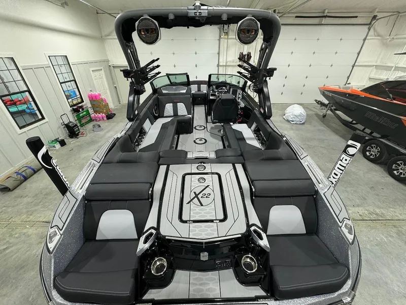 Slide: The Image of 2024 MasterCraft X22 boat interior in a garage, showcasing seating and advanced audio system. - 15
