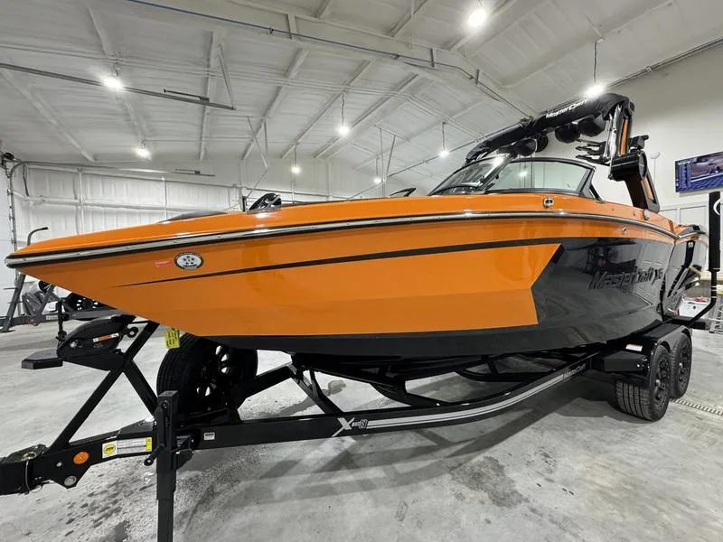 Slide: The Image of 2024 MasterCraft XStar S boat in orange and black on a trailer in a warehouse. - 5