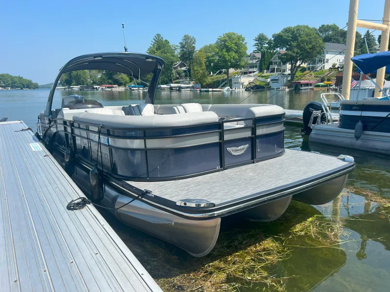 The Image of 2022 Bennington 28RSRX1 pontoon boat docked on a sunny lake. - 0