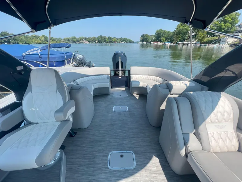 Slide: The Image of 2022 Bennington 28RSRX1 pontoon boat interior with luxurious seating on a serene lake. - 1