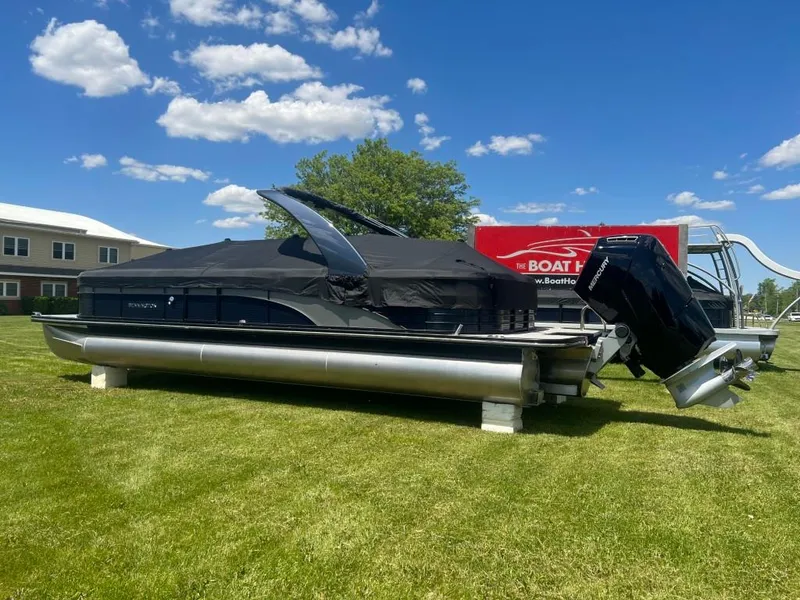 Slide: The Image of 2022 Bennington 28RSRX1 pontoon boat with Mercury outboard motor on grass. - 4