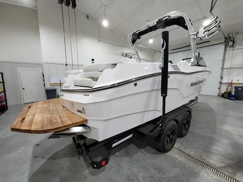 Slide: The Image of 2024 MasterCraft XT24 boat on trailer in indoor storage facility. - 10
