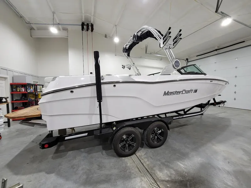 Slide: The Image of 2024 MasterCraft XT24 boat on trailer in a garage. - 11