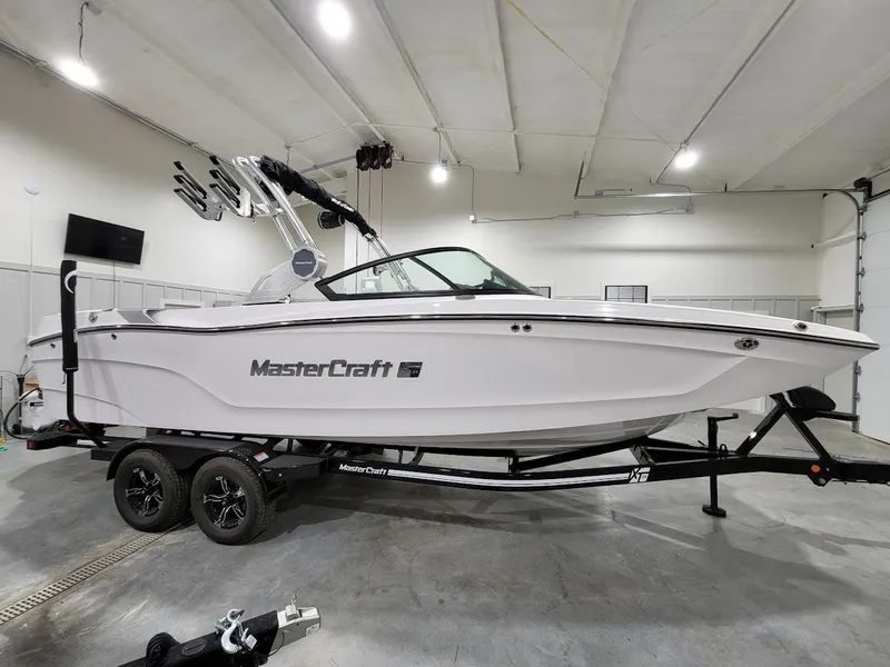Slide: The Image of 2024 MasterCraft XT24 boat on trailer in indoor storage. - 12