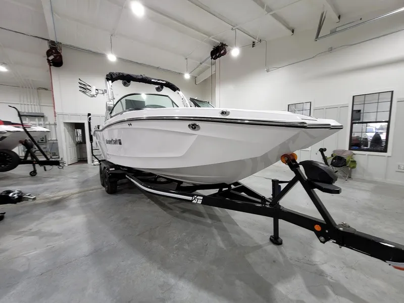 Slide: The Image of 2024 MasterCraft XT24 boat on trailer in indoor showroom. - 13