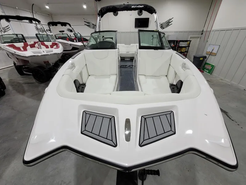 Slide: The Image of 2024 MasterCraft XT24 boat in showroom, front view. - 14