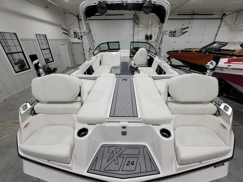 Slide: The Image of 2024 MasterCraft XT24 boat with luxurious white seating in a showroom. - 16