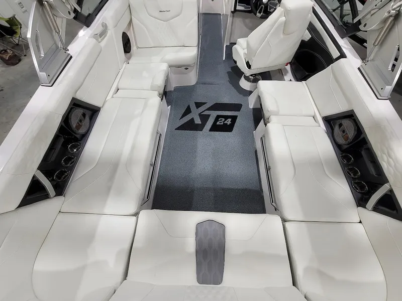 Slide: The Image of 2024 MasterCraft XT24 boat interior with white seating and XT24 logo on floor. - 17