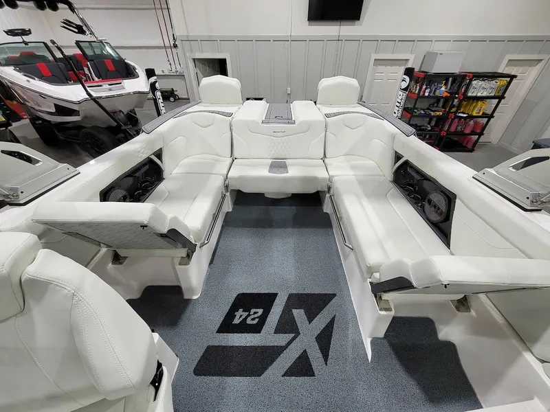 Slide: The Image of 2024 MasterCraft XT24 boat interior with white seating and carpeted floor. - 18