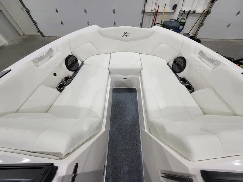 Slide: The Image of 2024 MasterCraft XT24 boat interior with white leather seating and cup holders. - 22