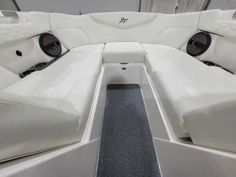 Slide: The Image of 2024 MasterCraft XT24 boat interior with white seating and built-in speakers. - 23