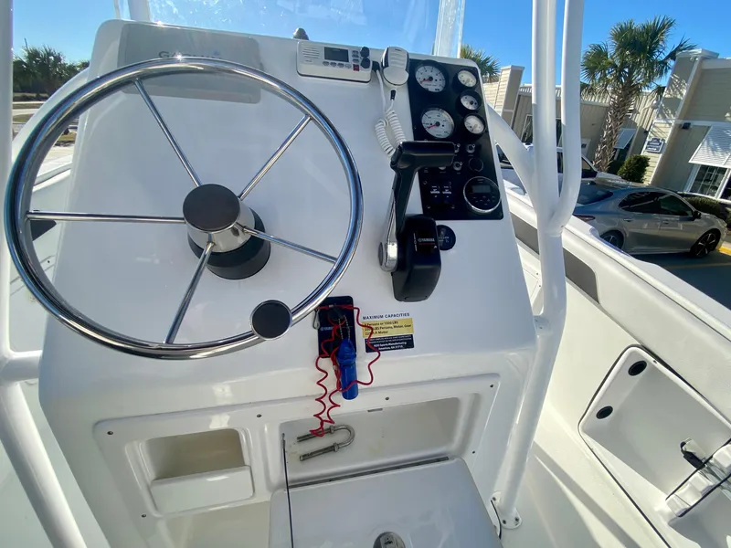 Slide: The Image of Clearwater 2200CC 2016 boat console with steering wheel and control panel. - 13