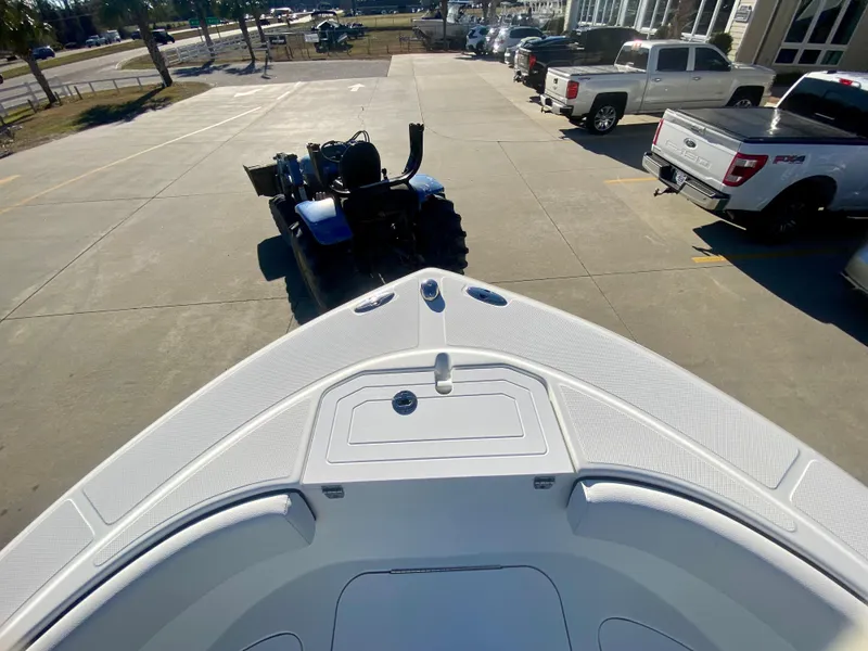 Slide: The Image of 2016 Clearwater 2200CC boat bow view in a parking lot with trucks and a tractor. - 23