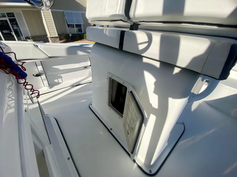 Slide: The Image of 2016 Clearwater 2200CC boat interior with white seating and storage compartment. - 12