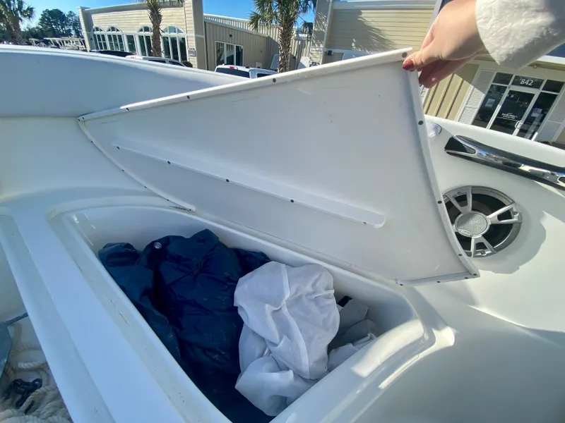 Slide: The Image of 2016 Clearwater 2200CC boat storage compartment with open lid and items inside. - 26