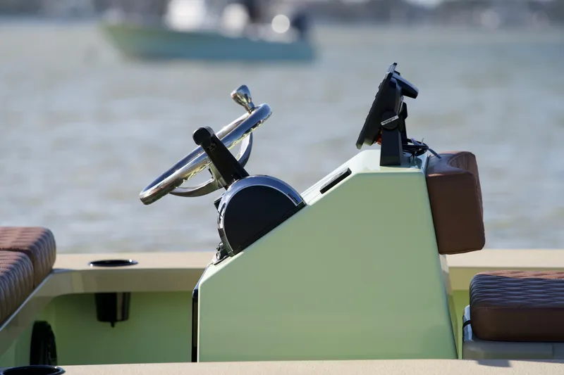 Slide: The Image of 2023 Cayo Boatworks 180 steering console on calm water. - 2