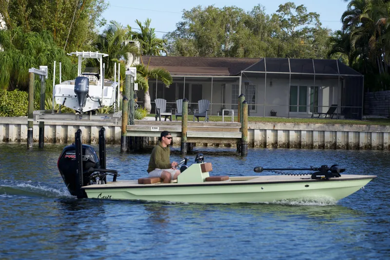 Slide: The Image of 2023 Cayo Boatworks 180 skiff cruising on a residential canal. - 24