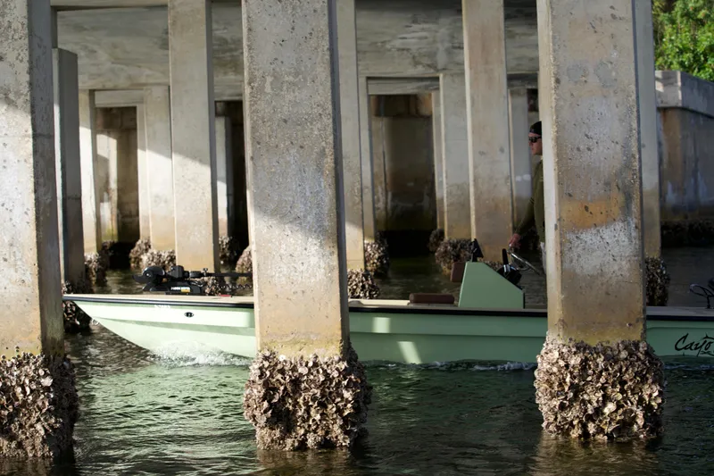 Slide: The Image of 2023 Cayo Boatworks 180 navigating under a concrete bridge. - 28