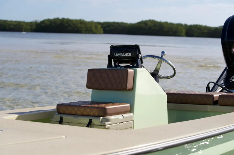 Slide: The Image of 2023 Cayo Boatworks 180 model, featuring a Lowrance system, on calm waters. - 3