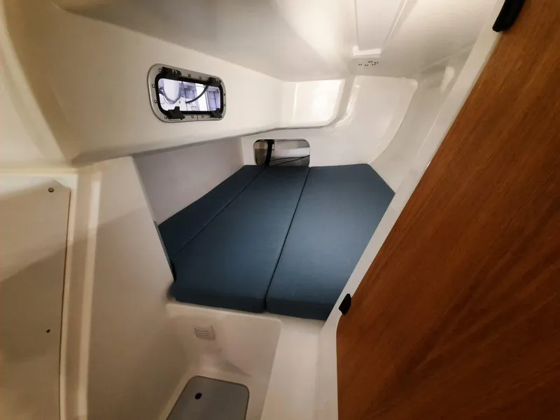 Slide: The Image of Interior cabin of 2024 M.A.T. 1070 sailboat with blue cushions and wooden accents. - 10
